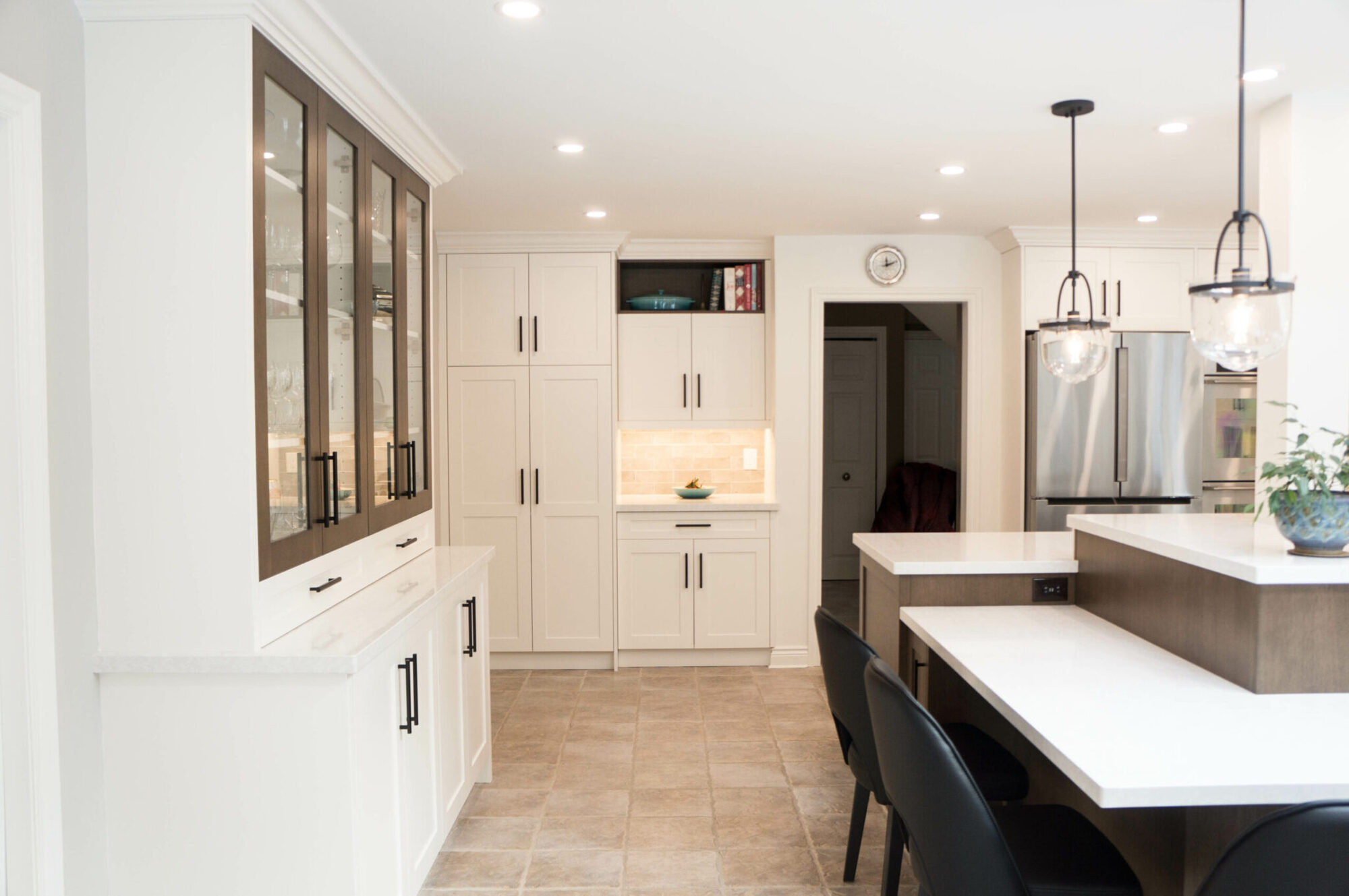 Kitchen with white countertops at varying heights and matching white cabinets.
