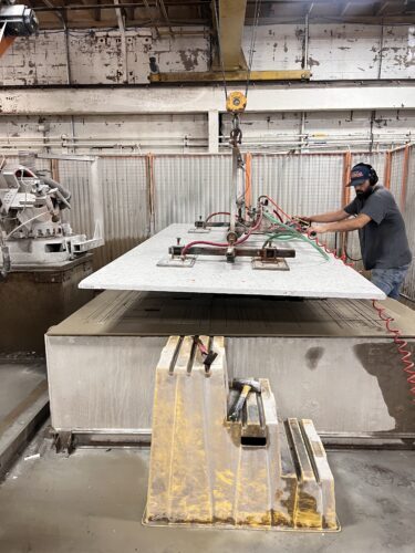 Rumford Stone staff carefully moving slabs of stone in a shop that safely practices wet cutting