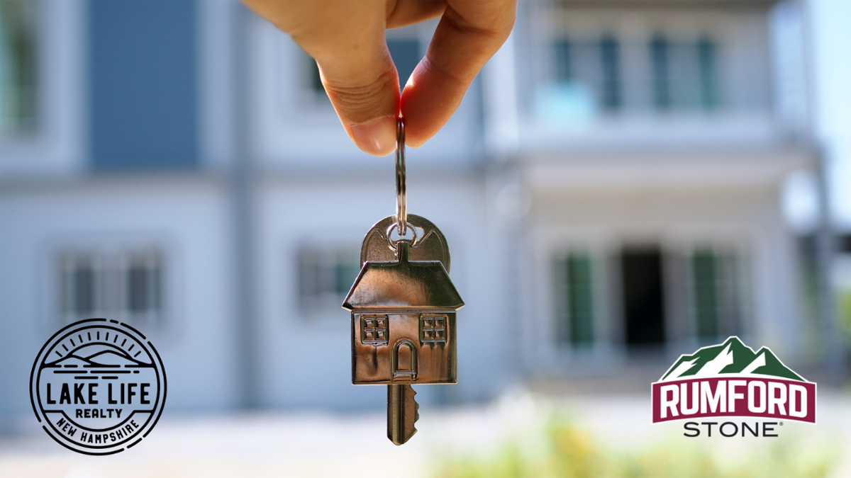 A person holding a house shaped key, with the Lake Life realty Logo and Rumford Stone logo.