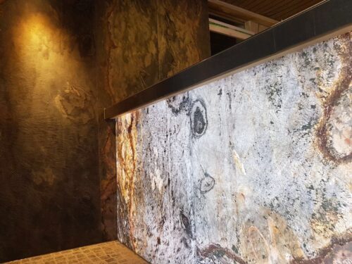 Close-up of a Skinrock translucent front desk counter illuminated with white lighting.