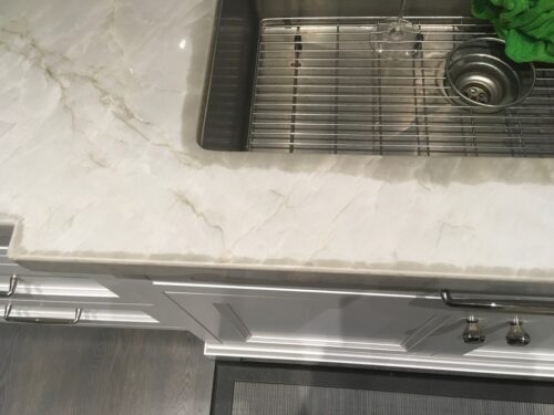 Countertop with naturally occurring quartzite water marks along the edges, a normal feature that dissipates over time and is not damage.