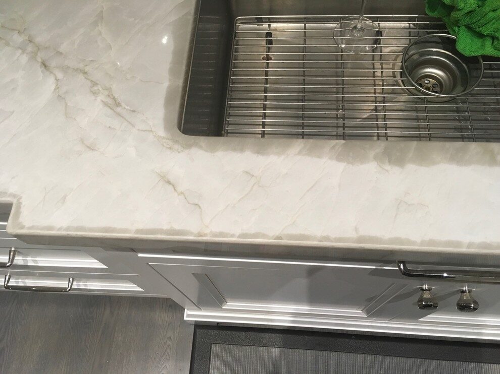 Countertop with naturally occurring quartzite water marks along the edges, a normal feature that dissipates over time and is not damage.